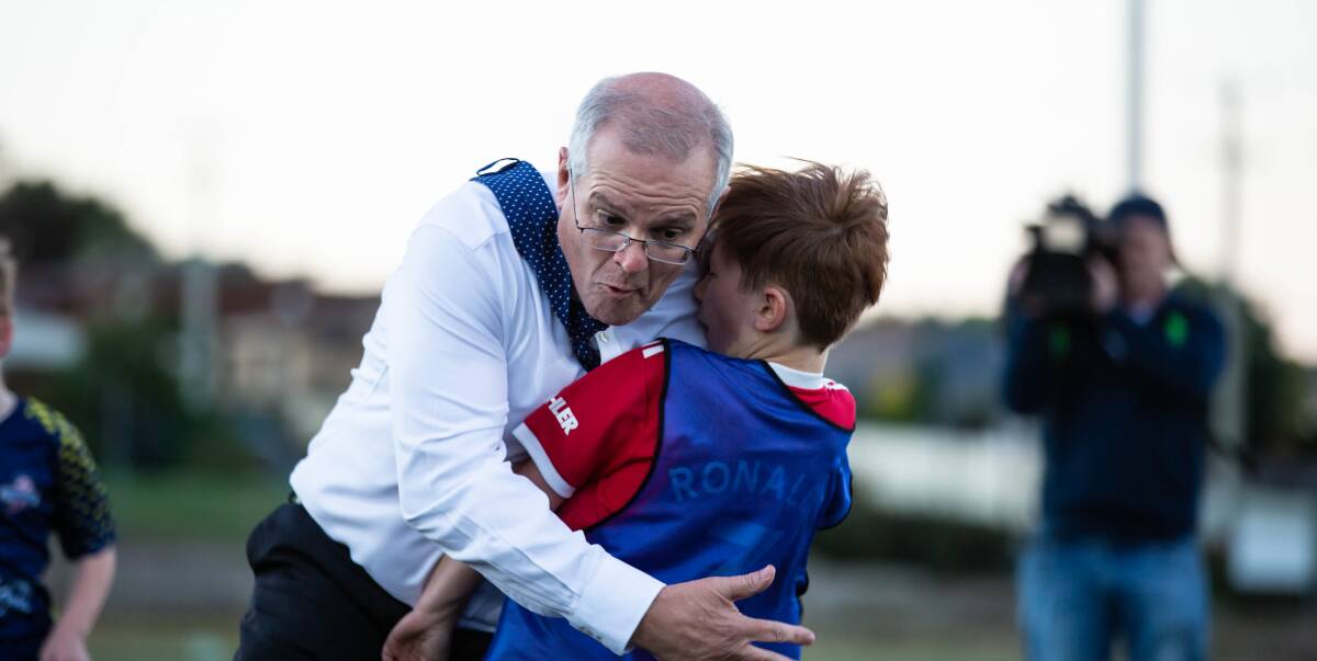 Prime Minister Scott Morrison accidentally crash-tackled under 8s football player, Luca Fauvette, on Wednesday afternoon in Devonport, Tasmania. Picture: Eve Woodhouse