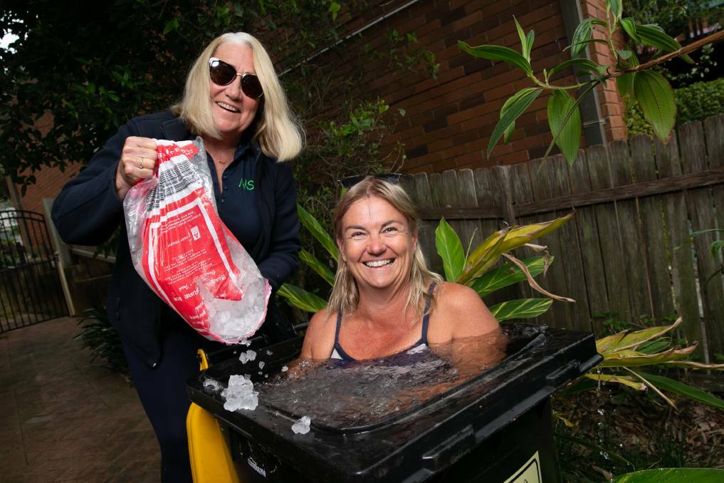 ICE COOL: Swimmer Charmian Frend submerging in a bin full of ice water, overseen by her coach Narelle Simpson. Picture: Geoff Jones