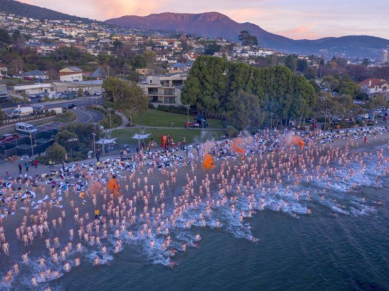 Swimmers participate in the 2021 Dark Mofo Nude Solstice Swim at Sandy Bay beach in Hobart.