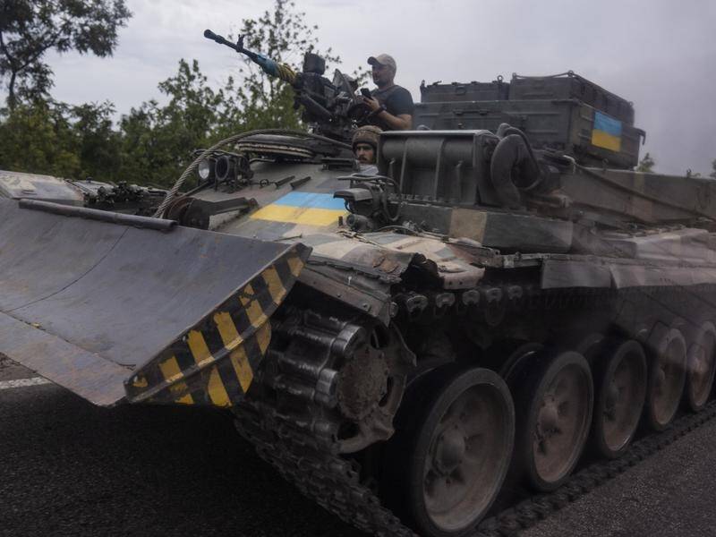 Ukrainian soldiers ride in a tank on a road in Stupochky, in the Donetsk region in eastern Ukraine.