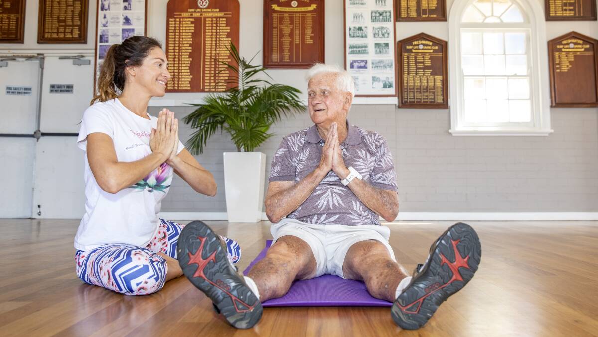 FEELING FIT: Local legend Mick Griffin, 91, doing yoga with teacher Sasha Hawley at Freshwater Surf Club. Picture: Dallas Kilponen