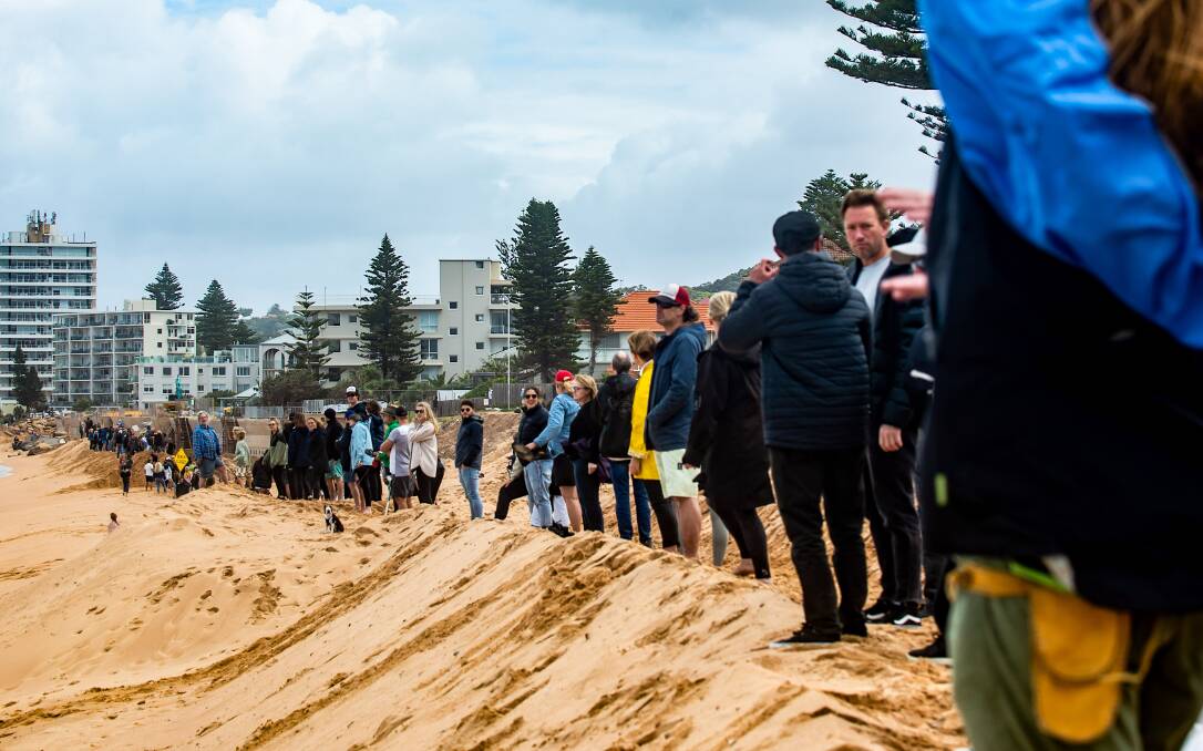 STOP NOW: Protestors formed a 'line in the sand' to call for an immediate halt to seawall construction that they say will destroy the beach. Picture: Mitch Clark