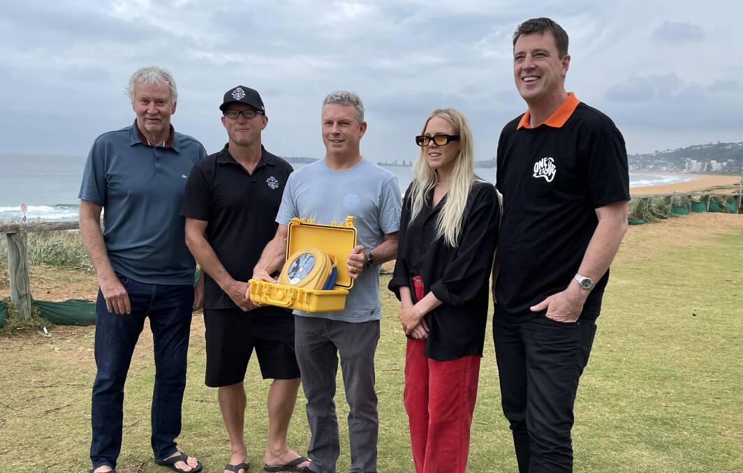HELP FOR ALL: North Narrabeen Boardriders Club members Simon Anderson, Brian Lawson, Damien Hardman, Laura Enever and Northern Beaches Council mayor Michael Regan with the defibrilator. Picture: Nadine Morton
