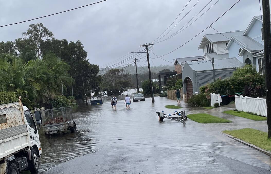 EVACUATE: Floodwaters rising up Malcolm Street in Narrabeen on Tuesday evening. Picture: Nadine Morton